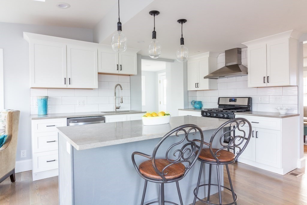 17 Andrews Street Danvers, MA 01923 - Photo 7 of 42 a kitchen with stainless steel appliances granite countertop a dining table chairs stove and white cabinets