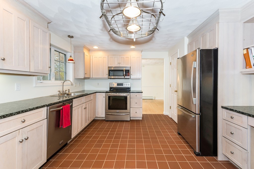 215 Bolton Road Lancaster, MA 01523 - Photo 3 of 14 a kitchen with granite countertop stainless steel appliances a sink cabinets and counter space