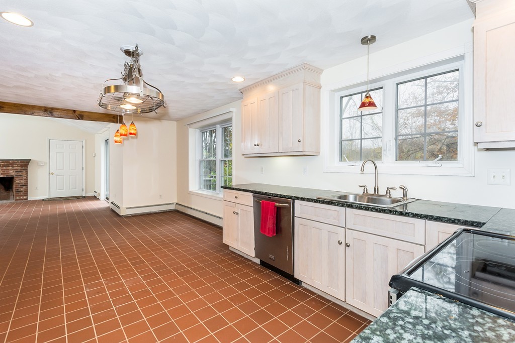 215 Bolton Road Lancaster, MA 01523 - Photo 4 of 14 a kitchen with stainless steel appliances granite countertop a sink dishwasher and white cabinets with wooden floor