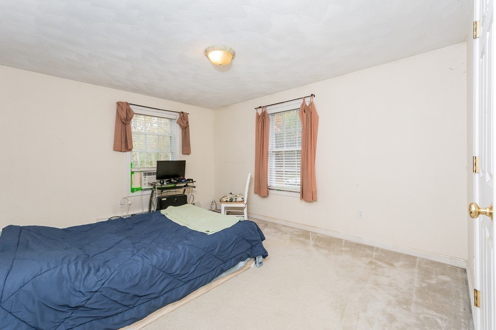 215 Bolton Road Lancaster, MA 01523 - Photo 10 of 14 a bedroom with a bed and wooden floor