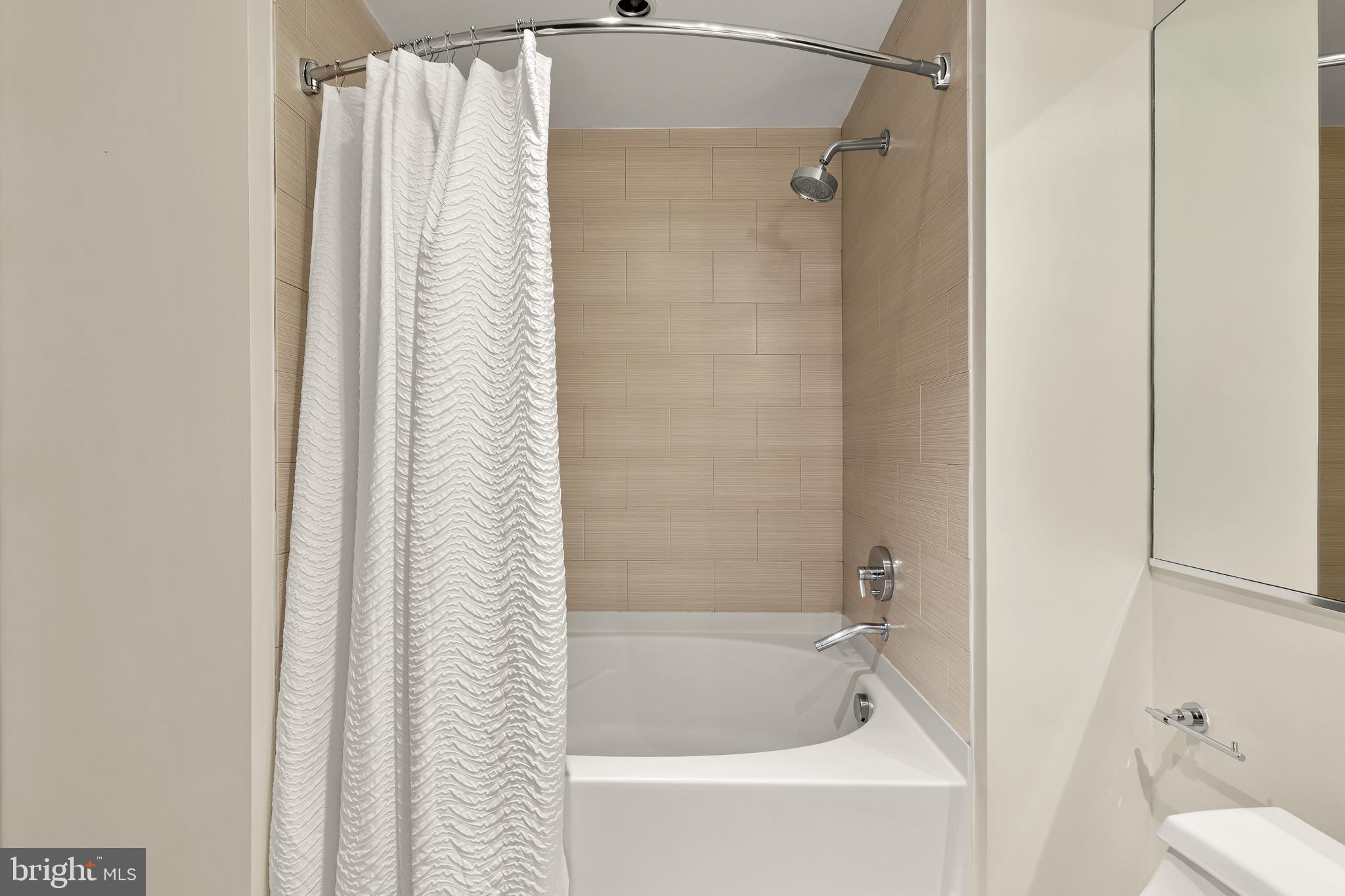 1010 Massachusetts Avenue Northwest, Unit 211 Washington, DC 20001 - Photo 18 of 27 a bathroom with a shower and a bath tub