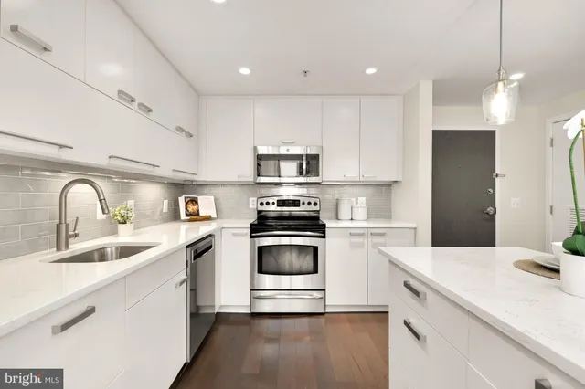 a kitchen with kitchen island a sink stainless steel appliances and cabinets