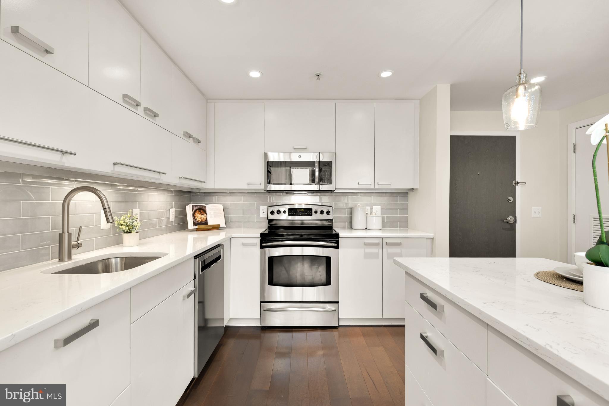1010 Massachusetts Avenue Northwest, Unit 211 Washington, DC 20001 - Photo 6 of 27 a kitchen with a sink cabinets and stainless steel appliances