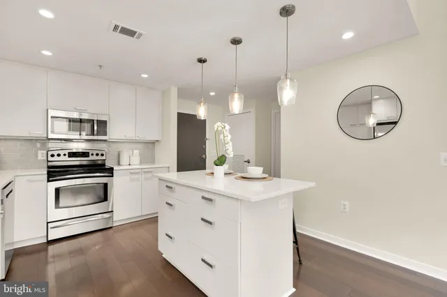 a kitchen with white cabinets and stainless steel appliances
