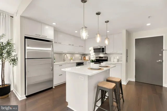 a kitchen with a refrigerator a sink and a stove top oven