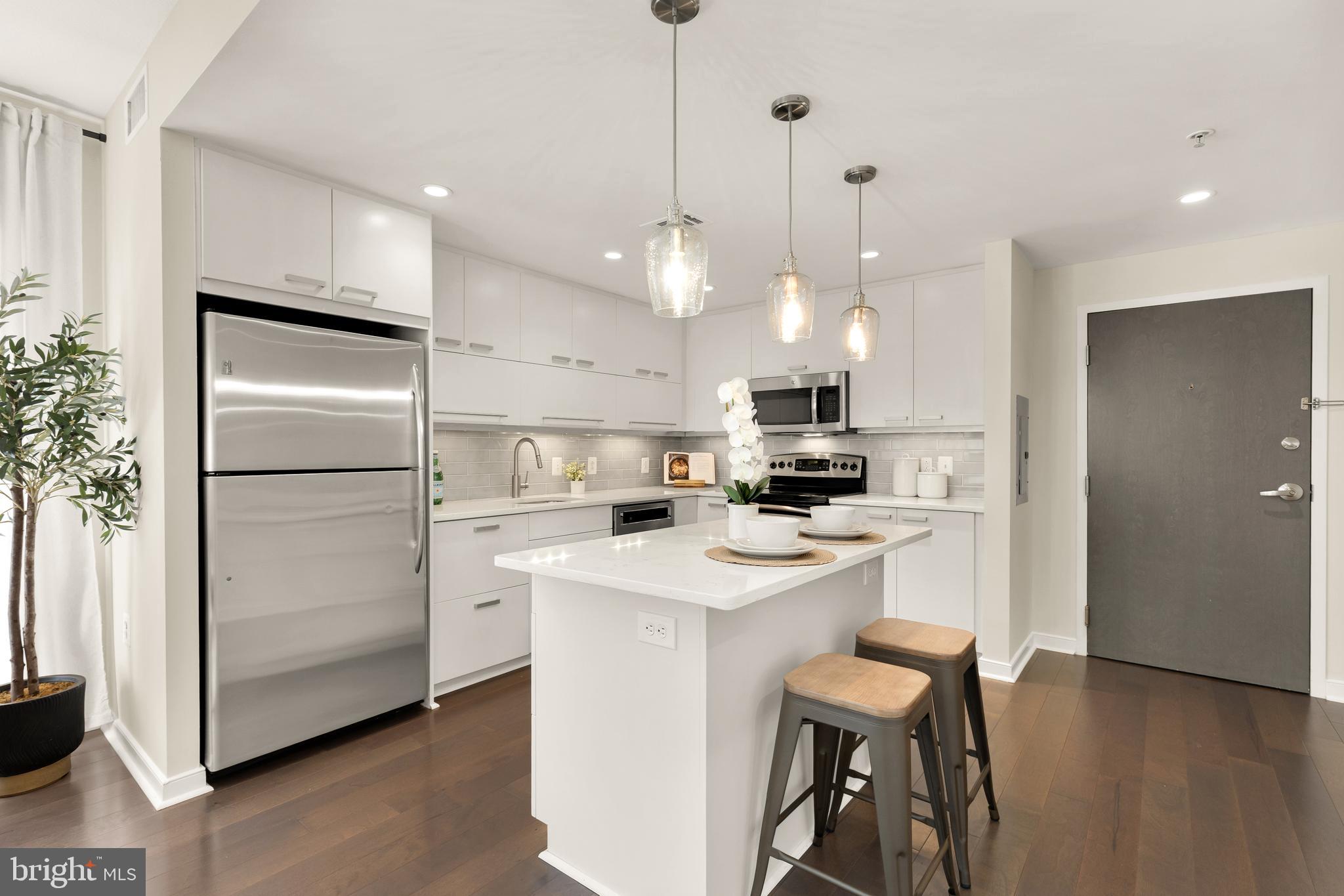 1010 Massachusetts Avenue Northwest, Unit 211 Washington, DC 20001 - Photo 8 of 27 a kitchen with white cabinets and stainless steel appliances