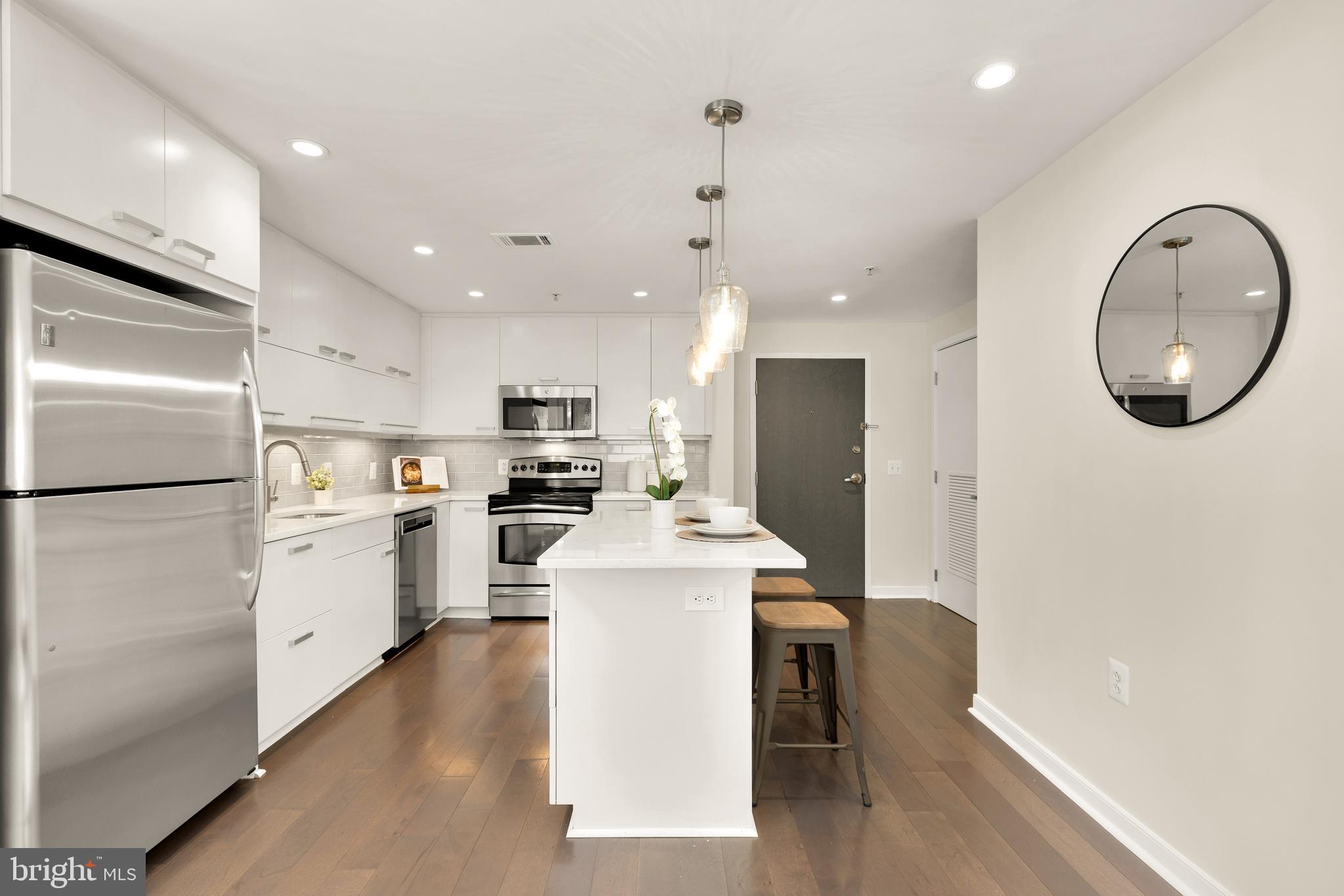 1010 Massachusetts Avenue Northwest, Unit 211 Washington, DC 20001 - Photo 9 of 27 a kitchen with a refrigerator a sink and a stove top oven