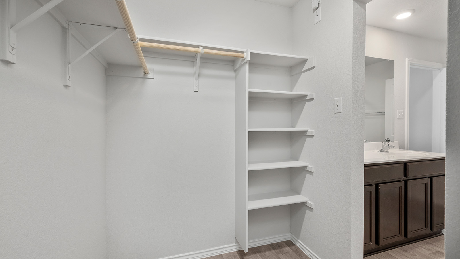 1418 Victory Rnch Trail Killeen, TX 76549 - Photo 14 of 22 Functional custom closet shelving offers ample storage solutions, adjacent to a vanity with a sleek countertop.