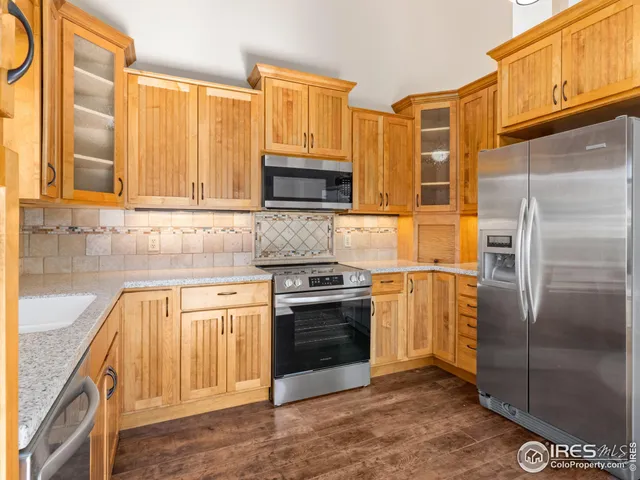 a kitchen with stainless steel appliances granite countertop a stove a sink and a microwave