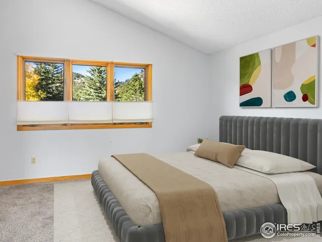 a view of a bedroom with window and wooden floor