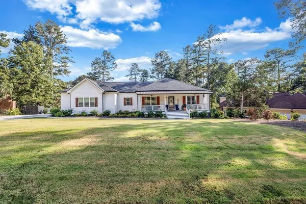 a front view of a house with swimming pool having outdoor seating