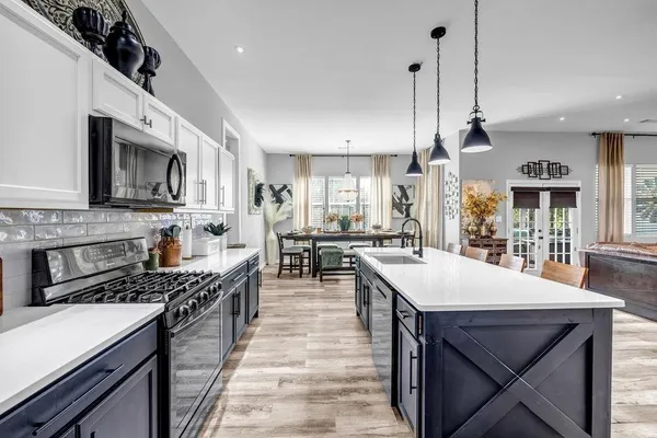 a kitchen with a stove a sink a dining table and chairs