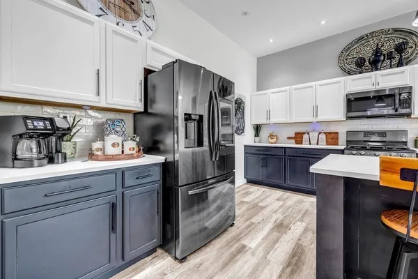 a kitchen with stainless steel appliances granite countertop a refrigerator a sink and a stove