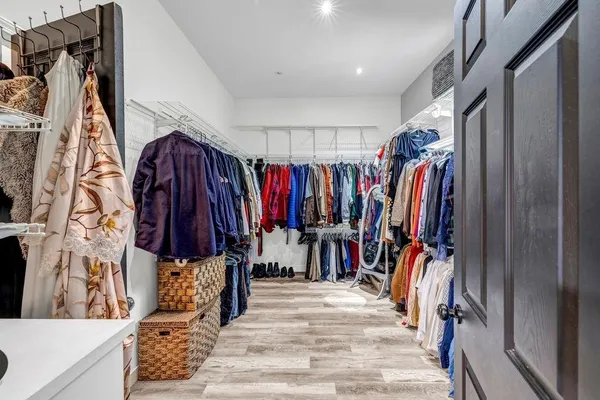 a view of walk in closet with clothes