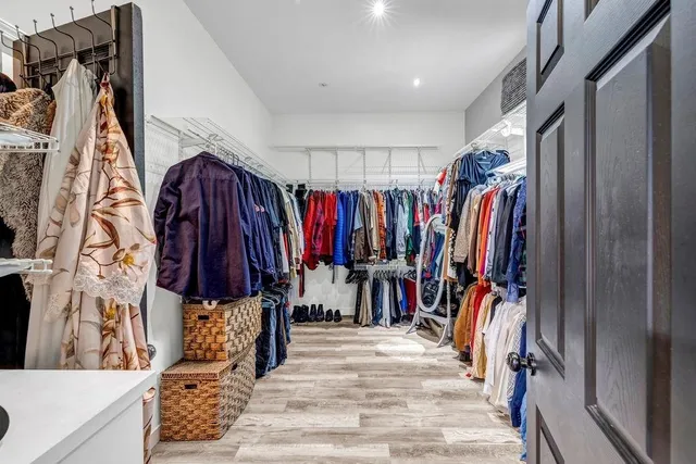 a view of walk in closet with clothes