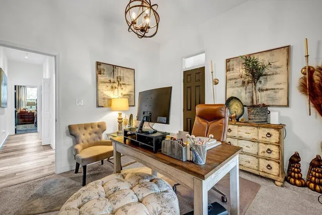 a living room with furniture a flat screen tv and a window