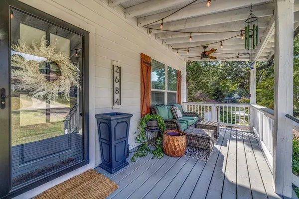 a view of a porch with wooden floor and furniture