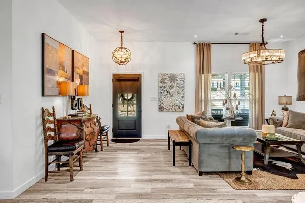 a living room with furniture a window and a chandelier
