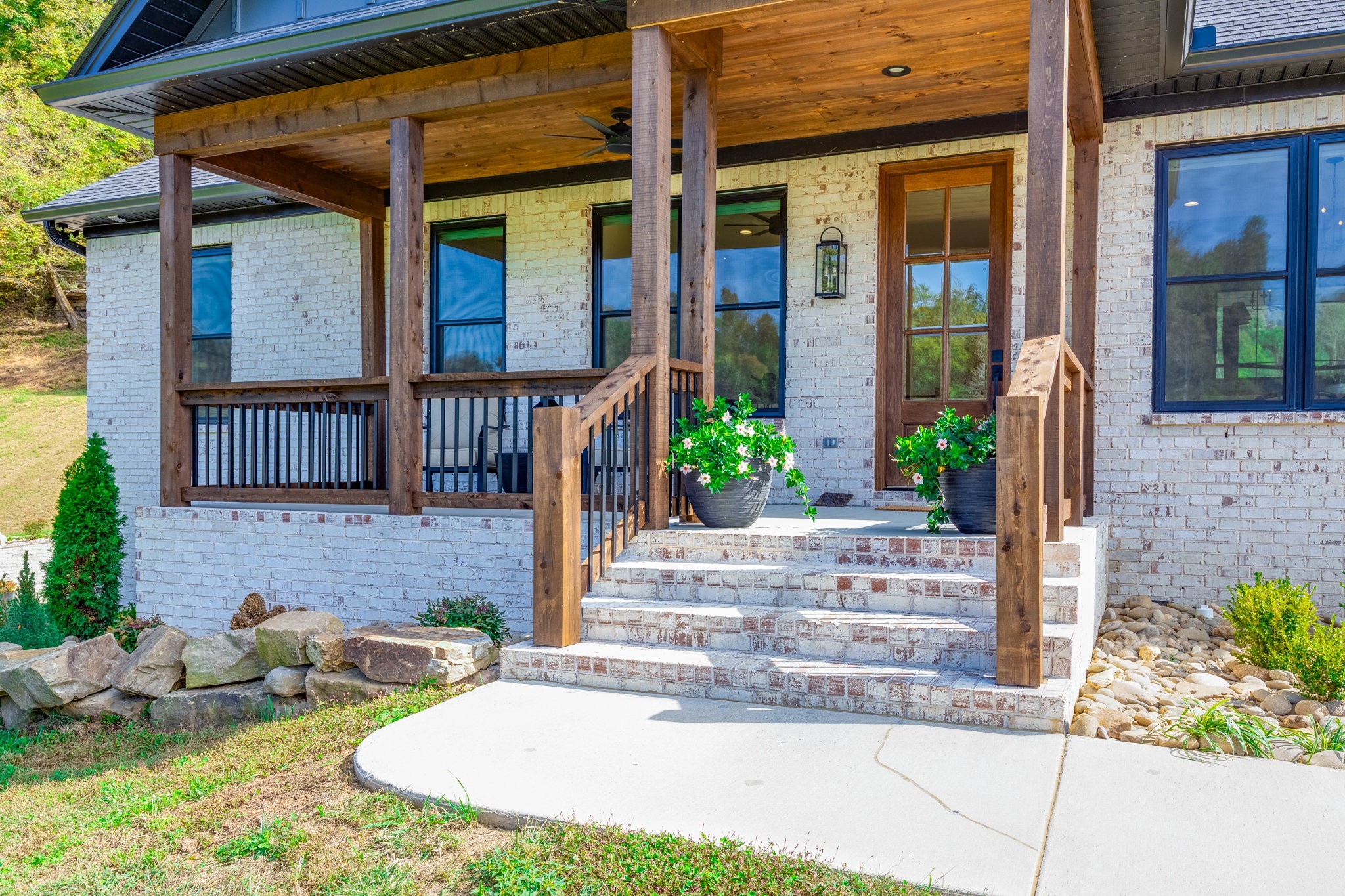 564 Mt Olive Cemetery Road Lynnville, TN 38472 - Photo 5 of 96 a view of brick house with potted plants and a bench in front of door
