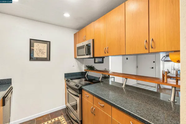 a kitchen with stainless steel appliances granite countertop a sink a stove and a refrigerator