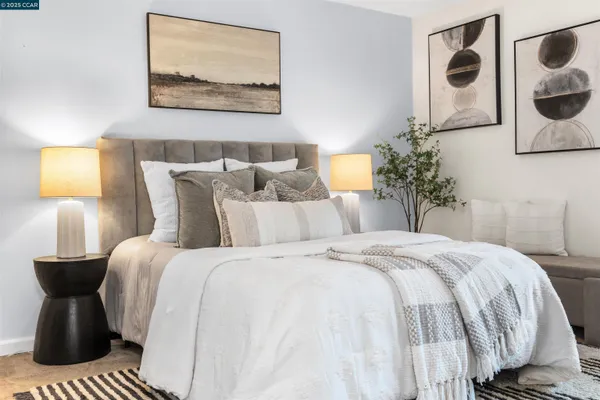 a bedroom with a bed and lamp painting on the wall