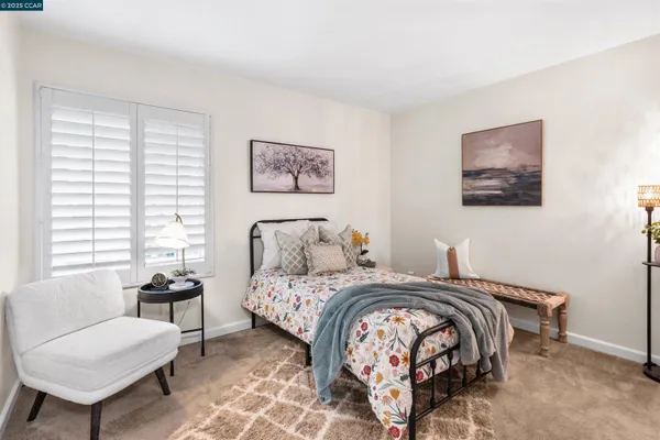 a bedroom with bed and a painting on the wall