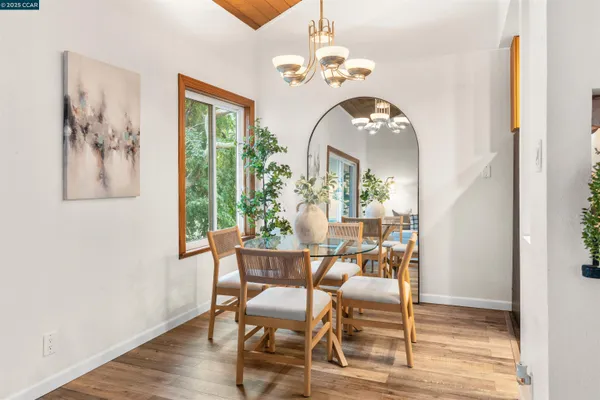 a view of a dining room with furniture a chandelier and wooden floor