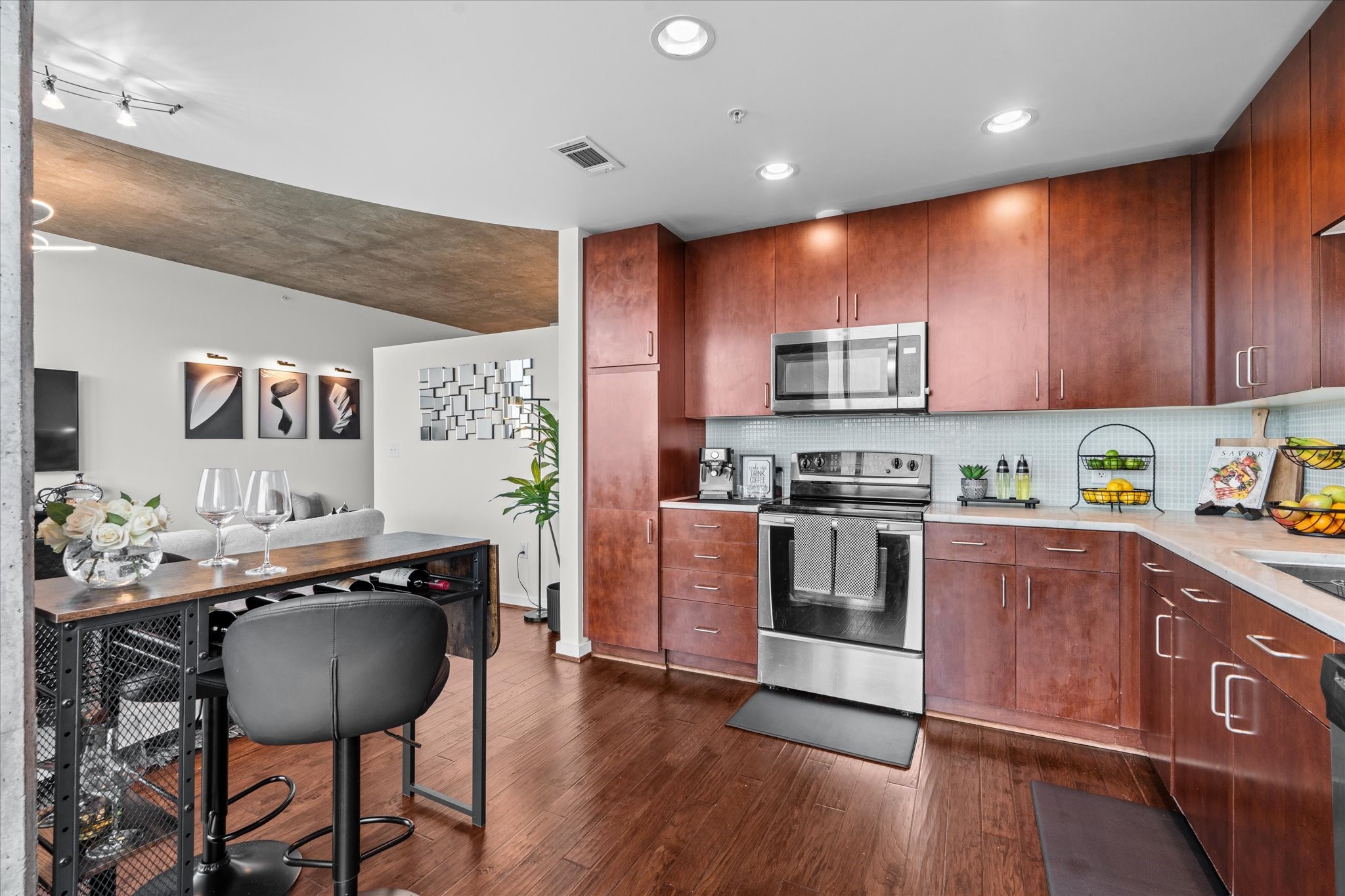 5925 Almeda Road, Unit 11107 Houston, TX 77004 - Photo 17 of 45 a kitchen with granite countertop wooden floors and stainless steel appliances
