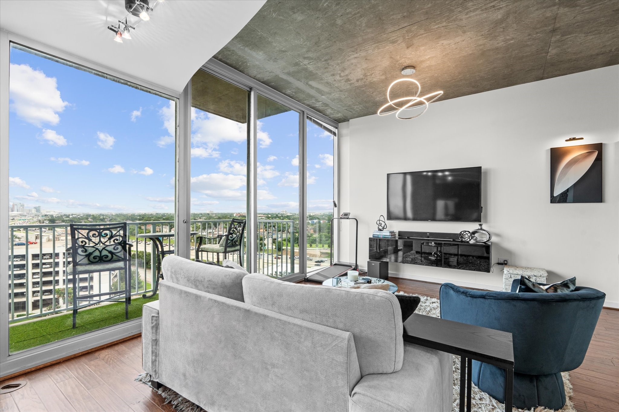 5925 Almeda Road, Unit 11107 Houston, TX 77004 - Photo 4 of 45 a living room with furniture a flat screen tv and a floor to ceiling window