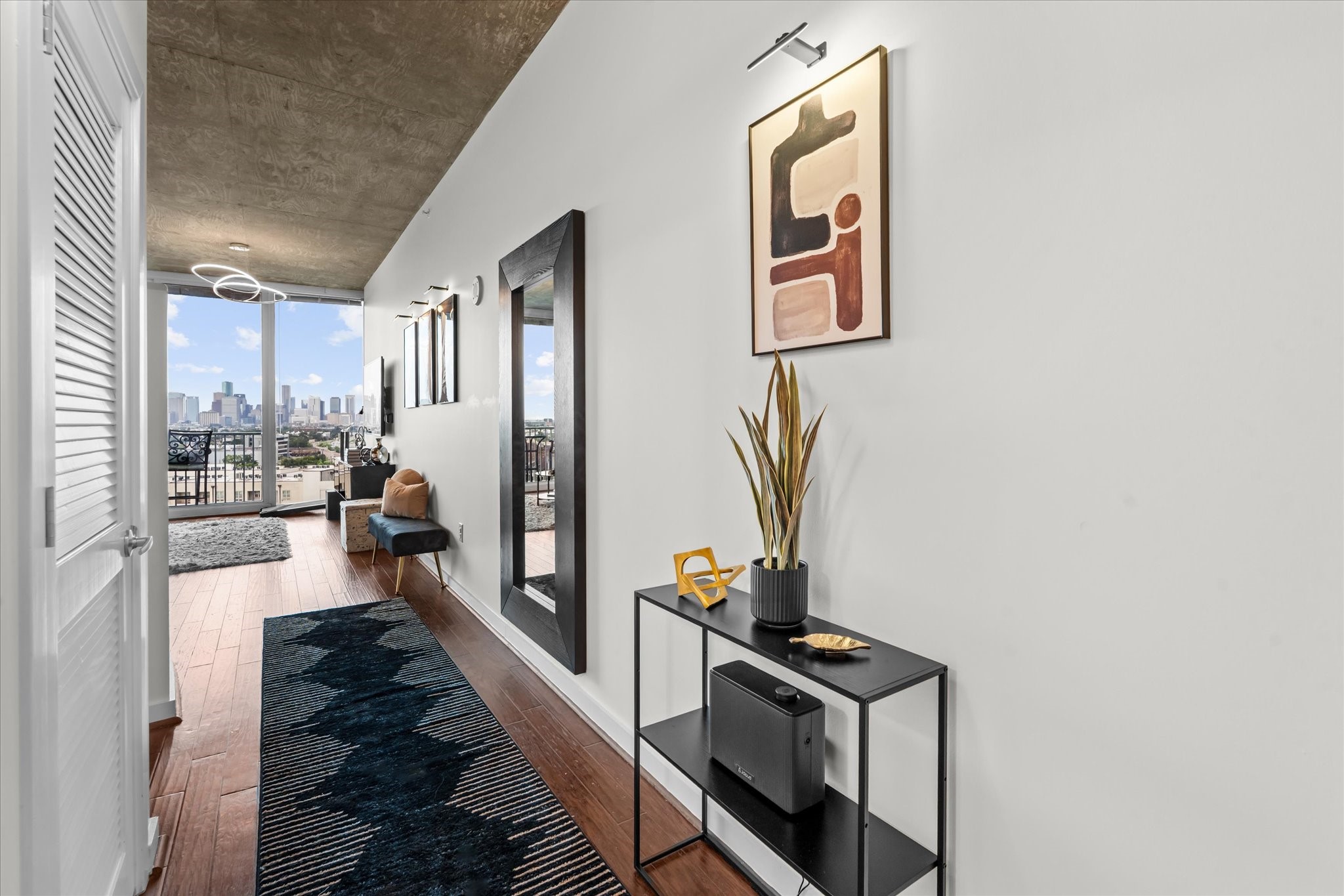5925 Almeda Road, Unit 11107 Houston, TX 77004 - Photo 6 of 45 a view of a hallway to a livingroom with wooden floor and furniture