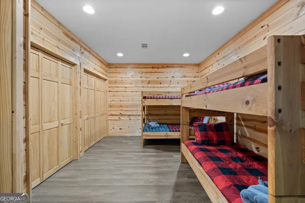 a view of a yard with plants and large trees