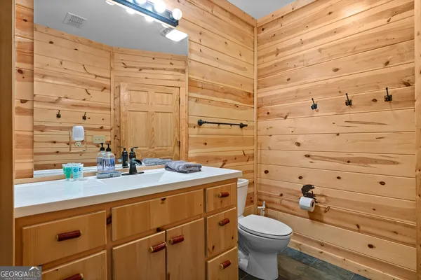 a view of a yard with plants and large trees