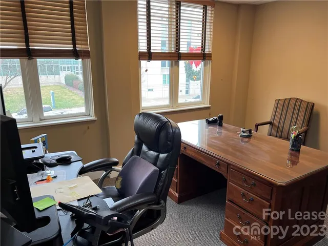 a view of a workspace with furniture and a window