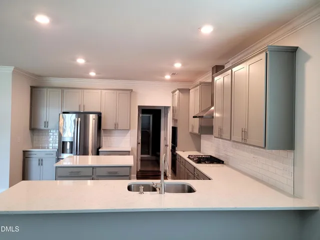 a kitchen with stainless steel appliances a refrigerator sink and stove