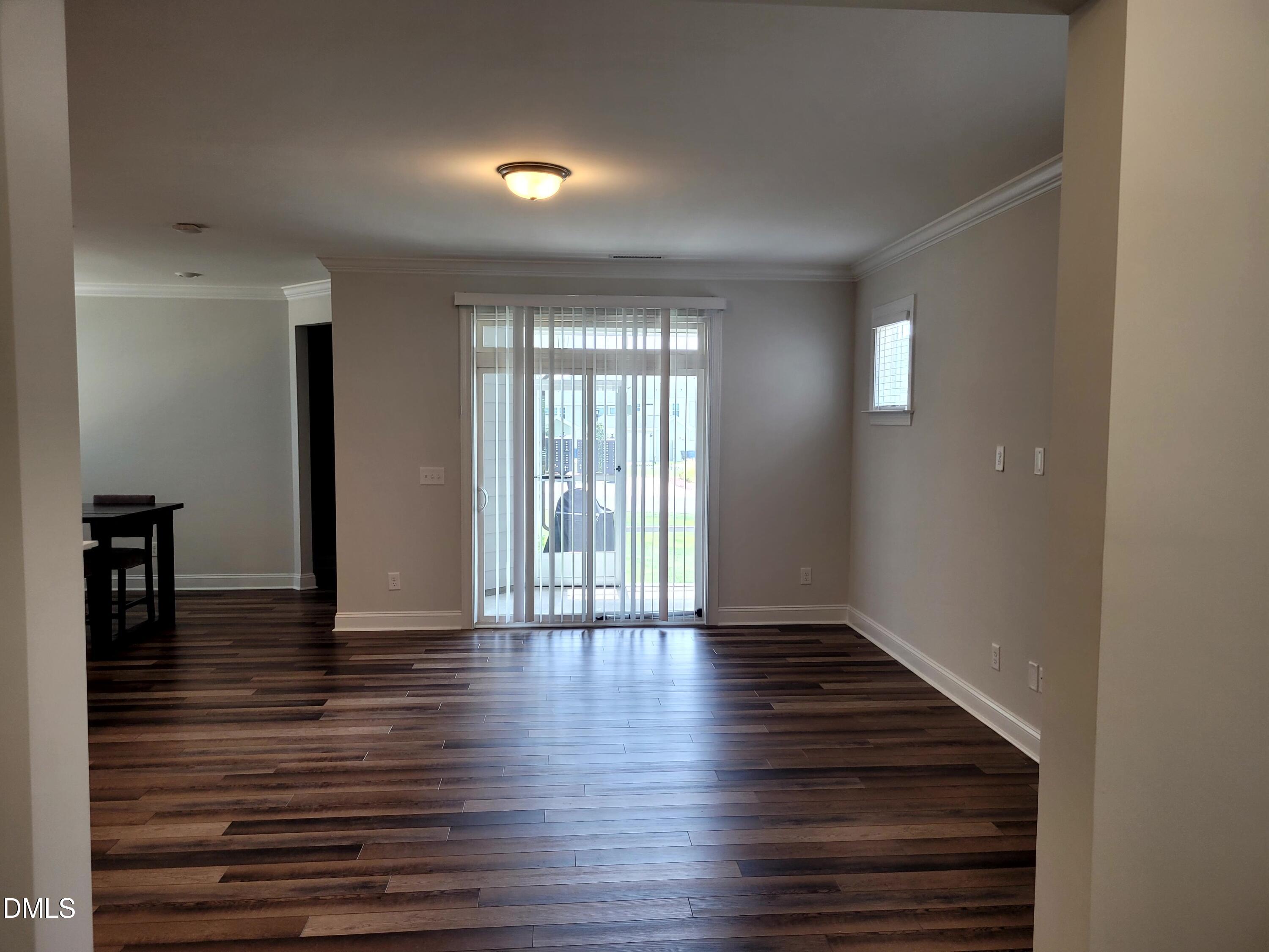 5220 Influence Way Raleigh, NC 27616 - Photo 4 of 10 a view of an empty room with wooden floor and a window
