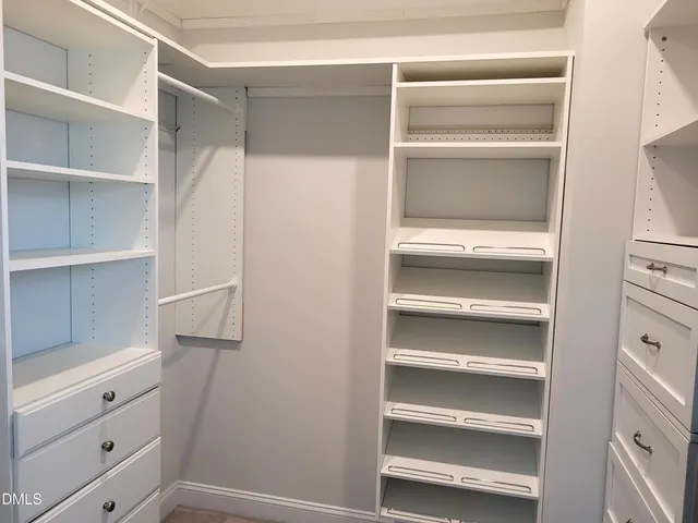 a view of walk in closet with empty racks