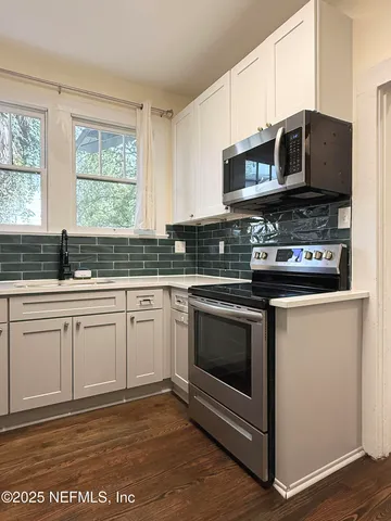 a kitchen with stainless steel appliances granite countertop a stove a microwave and a sink