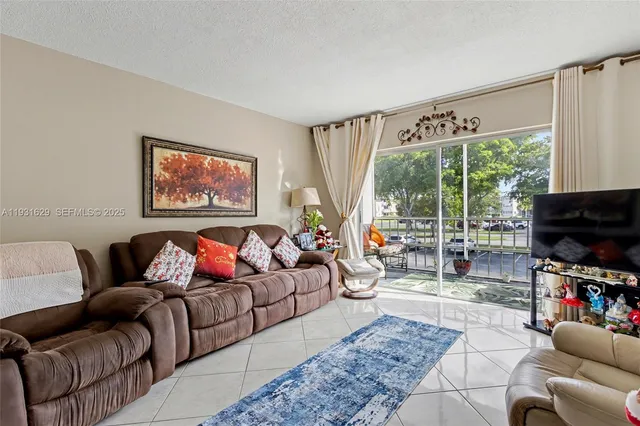 a living room with furniture a flat screen tv and a large window