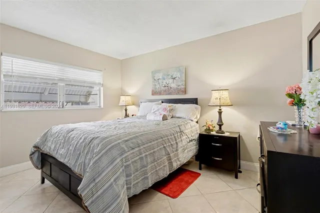 a bedroom with a bed and a potted plant