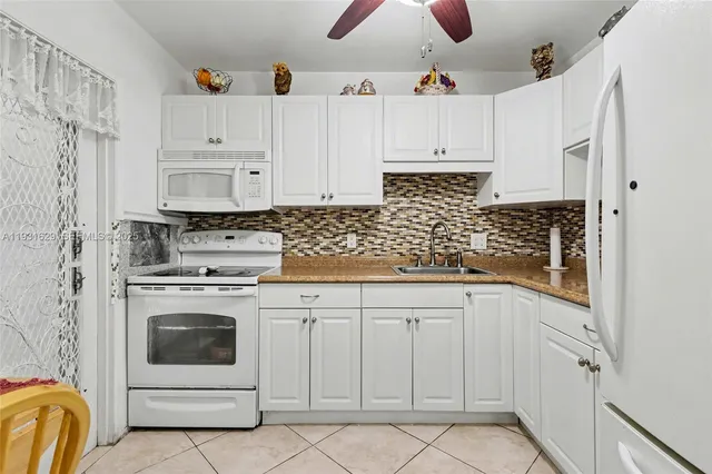 a kitchen with white cabinets and white appliances