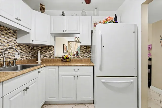 a kitchen with refrigerator and cabinets