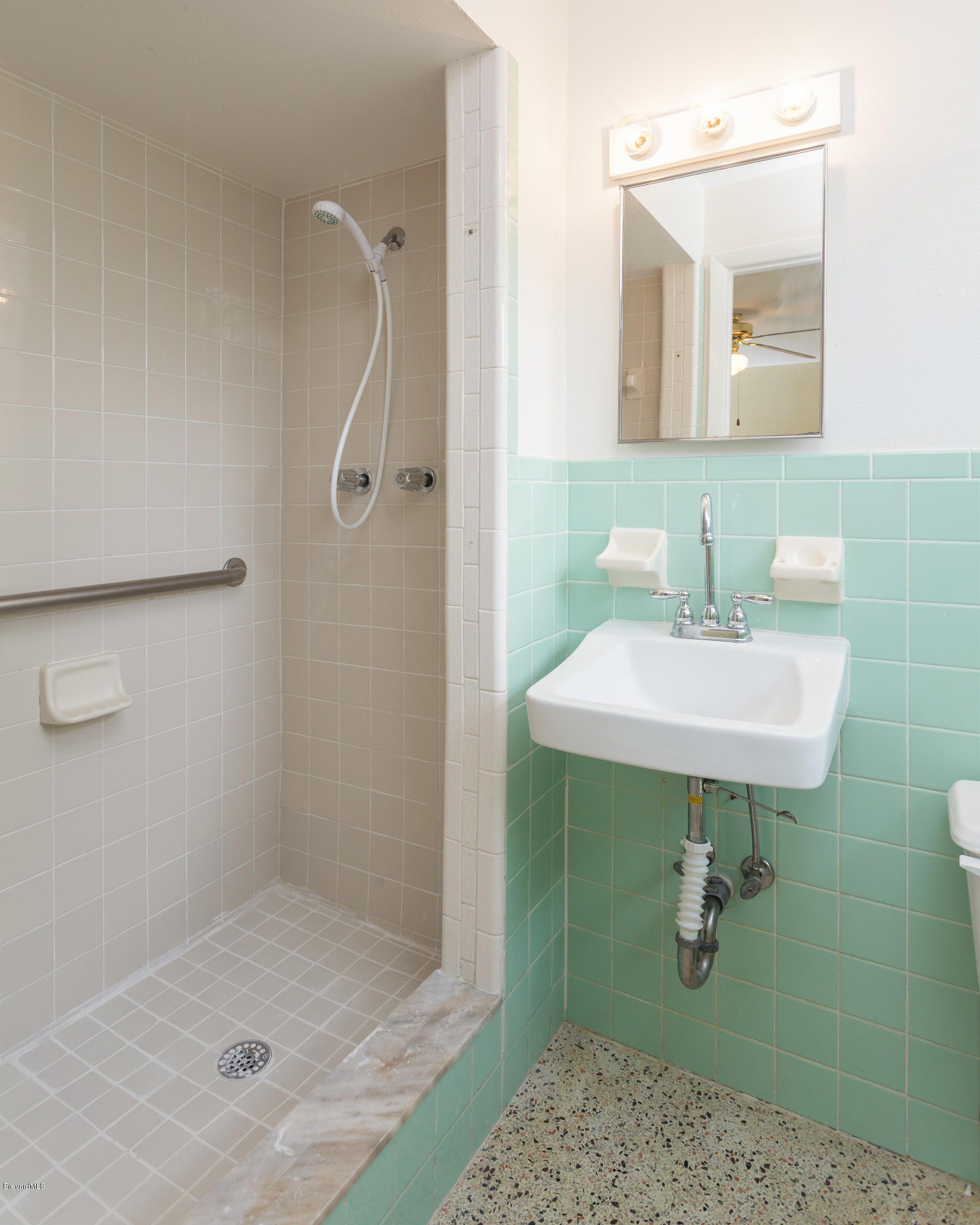 820 Sandgate Street Merritt Island, FL 32953 - Photo 8 of 13 a bathroom with a sink a mirror and shower