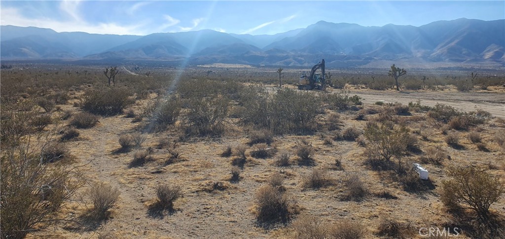 a view of a dry yard with mountains in the background