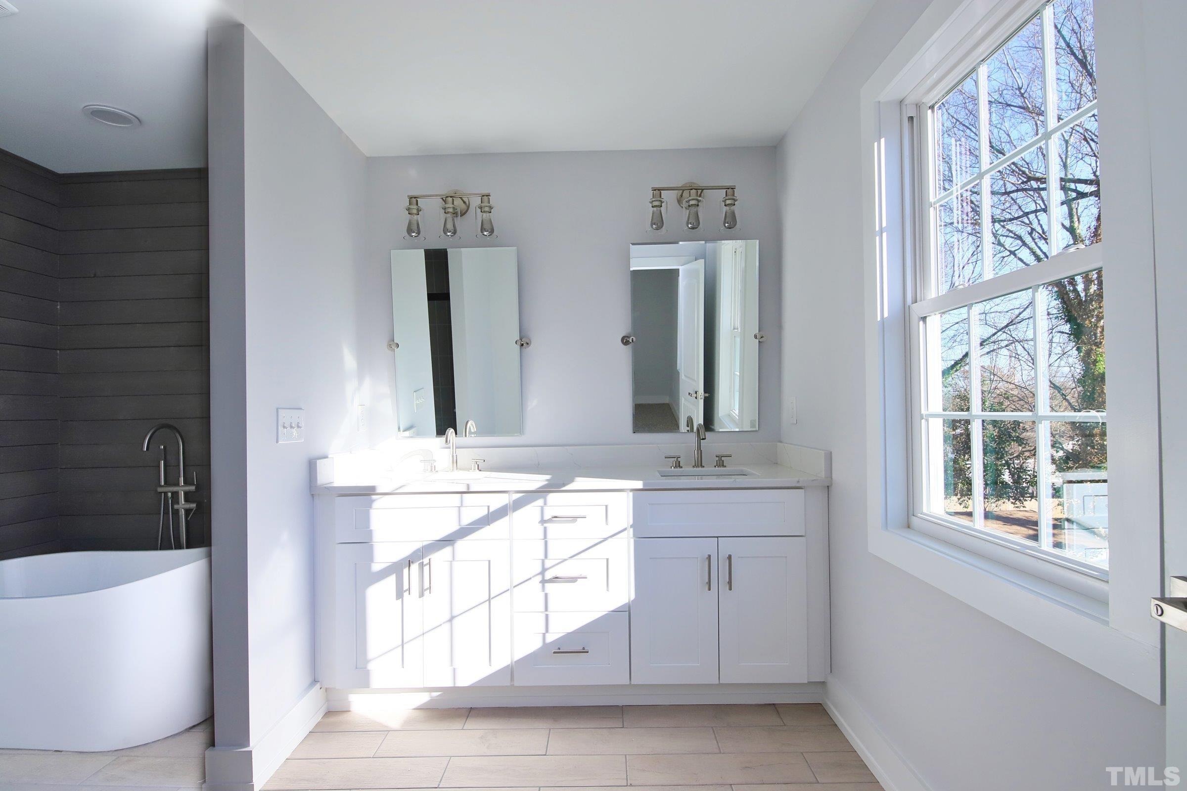 1412 East Jones Street Raleigh, NC 27610 - Photo 22 of 41 a spacious bathroom with a bathtub sink and mirror
