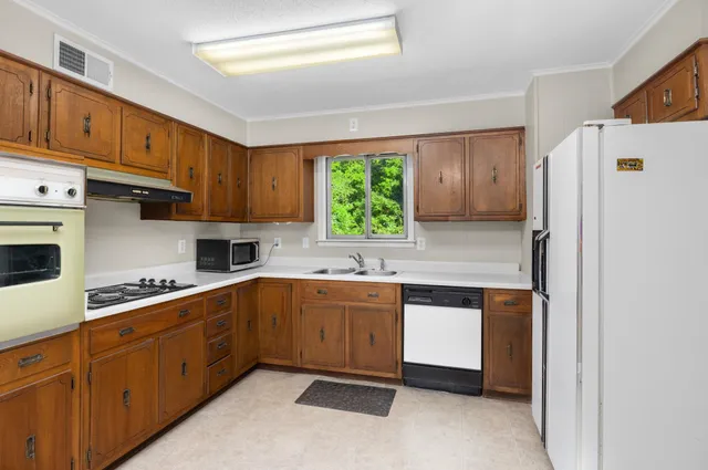 a kitchen with kitchen island granite countertop cabinets and white appliances