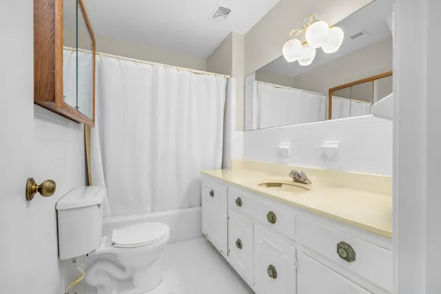 a bathroom with a double vanity sink mirror and toilet