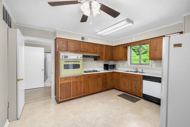a kitchen with stainless steel appliances kitchen island granite countertop a refrigerator and a stove top oven