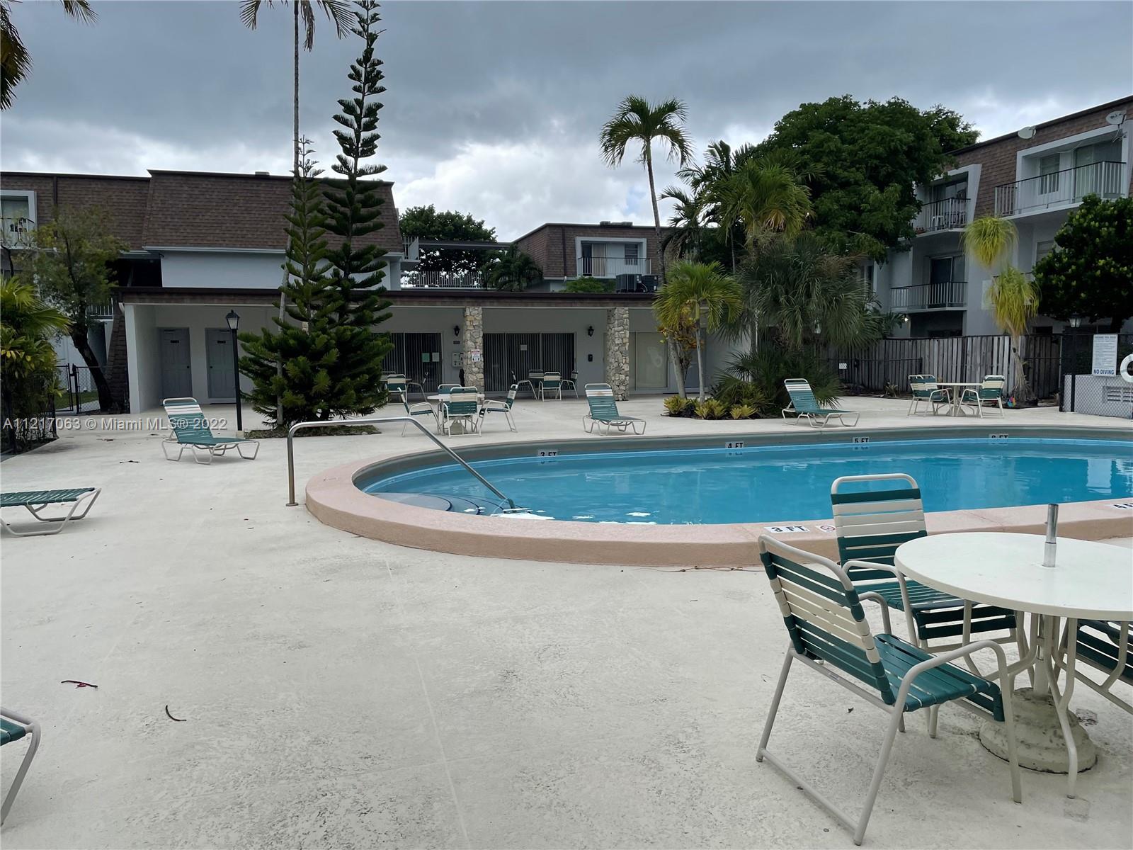 9611 Southwest 77th Avenue, Unit 108A Miami, FL 33156 - Photo 3 of 12 a view of a house with pool and chairs