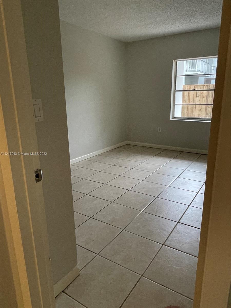 9611 Southwest 77th Avenue, Unit 108A Miami, FL 33156 - Photo 7 of 12 a view of an empty room and a window