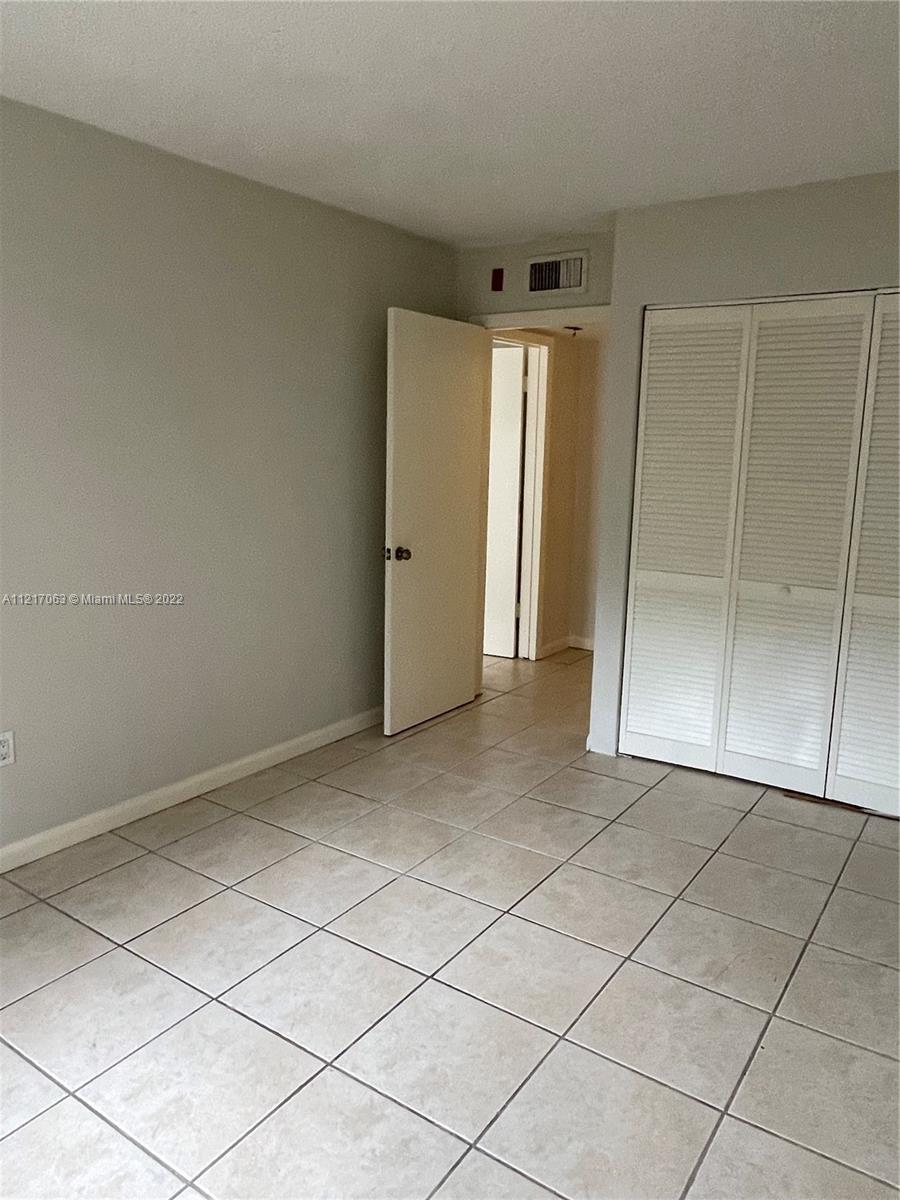 9611 Southwest 77th Avenue, Unit 108A Miami, FL 33156 - Photo 8 of 12 a view of an empty room and window